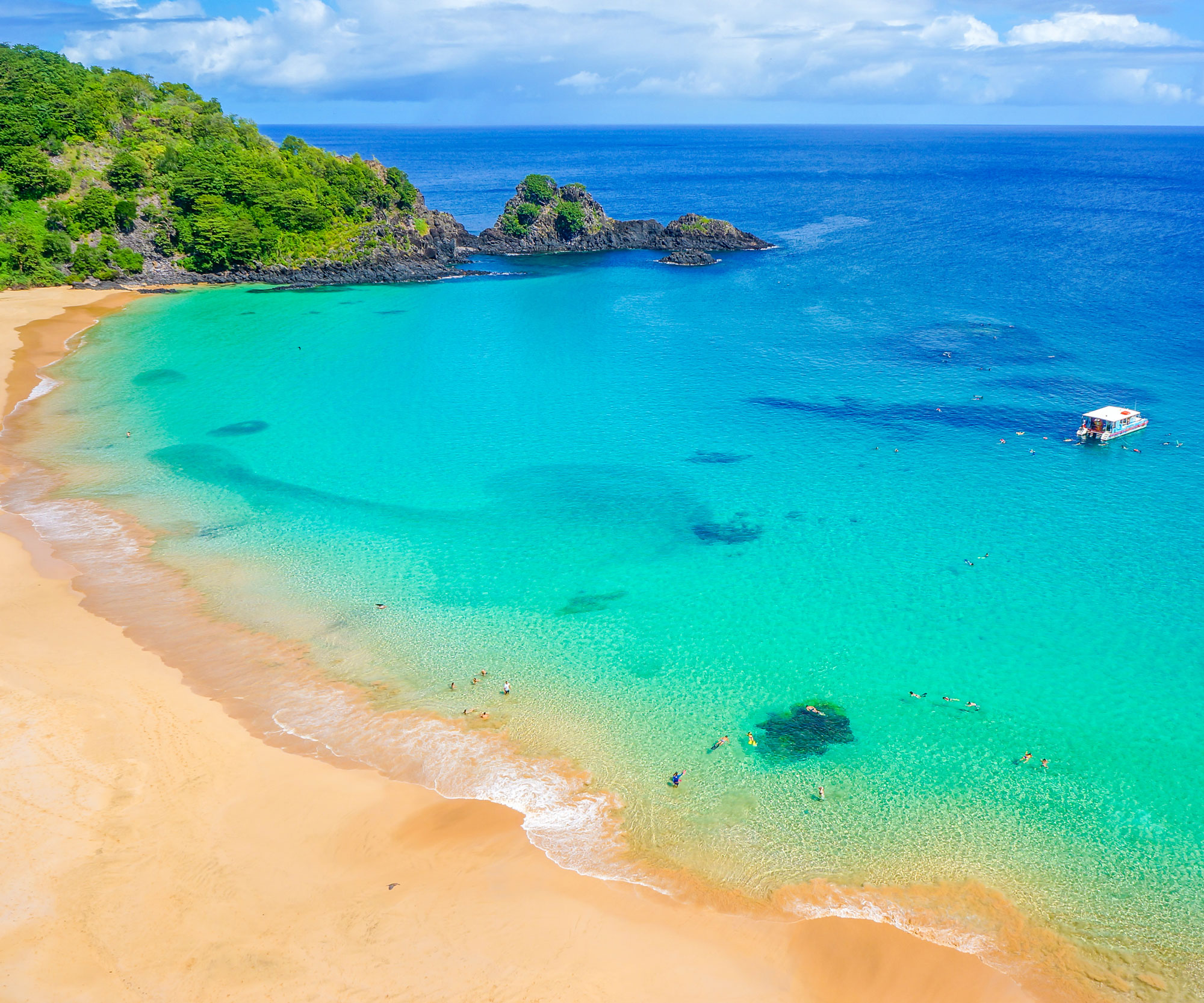 Praia do Sancho beach in Brazil with people and boat